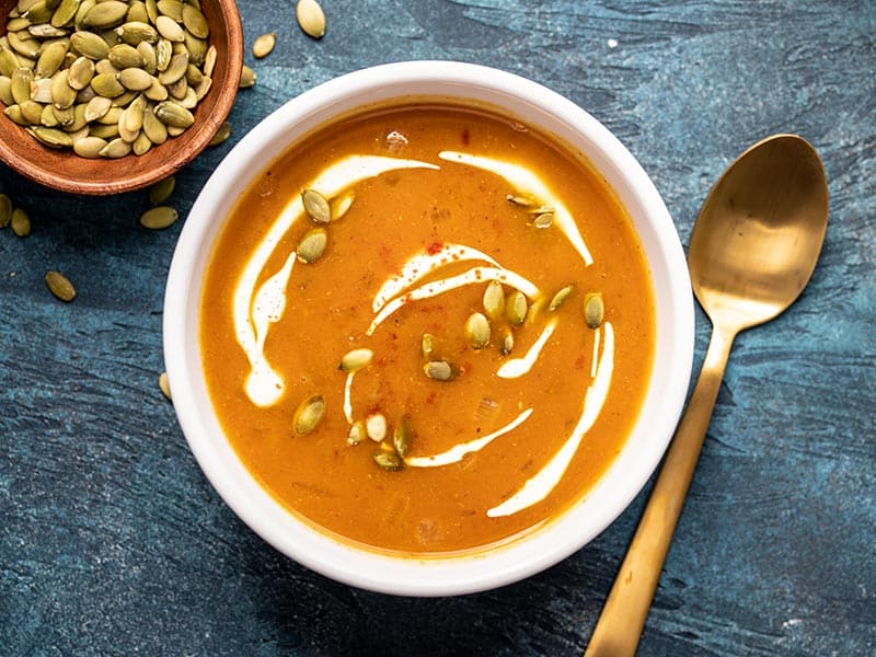 This flavorful and easy pumpkin soup takes less than 30 minutes to make and is the perfect simple side for a gooey grilled cheese sandwich! BudgetBytes.com One bowl of Easy Pumpkin Soup garnished with sour cream and pepitas