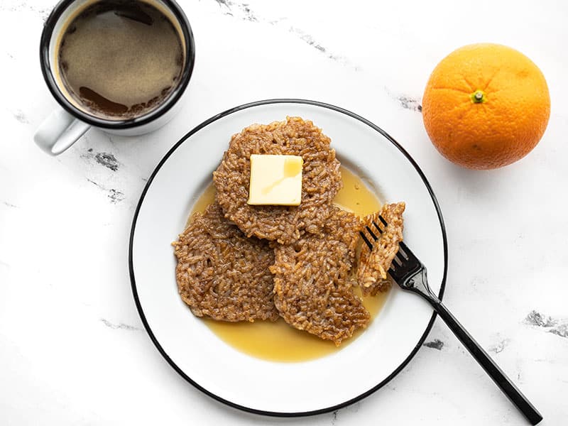 Use your leftover rice from the night before to make these quick and easy Rice Pancakes for breakfast. Reduce food waste and keep your budget in check! BudgetBytes.com Rice pancakes on a plate with butter and maple syrup, a fork stuck through a bite of pancake.