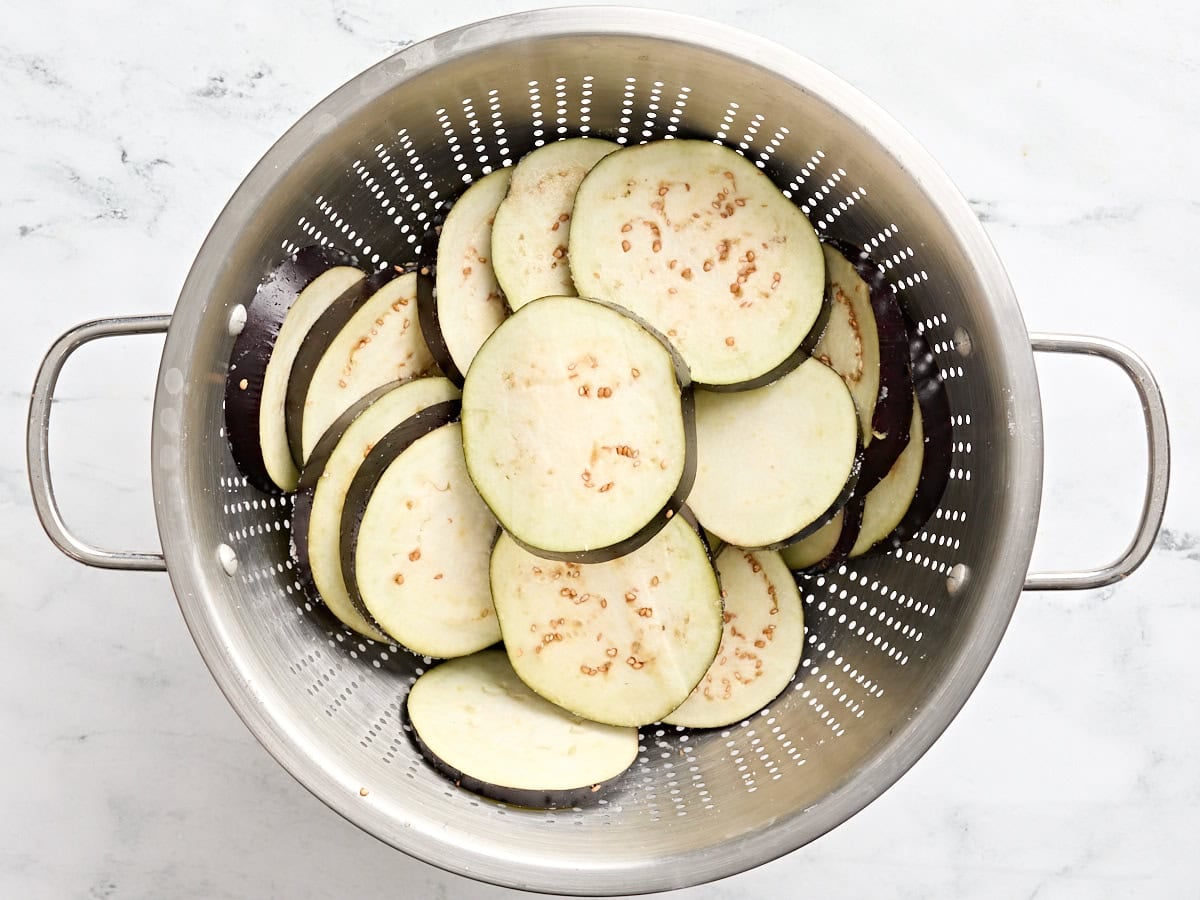 Sliced eggplant in a colander.