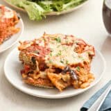 Side view of a slice of eggplant parmesan on a plate.