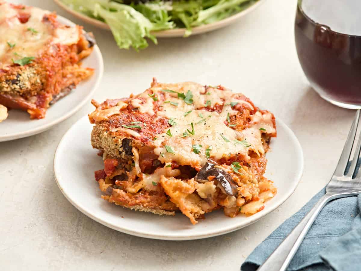 Side view of a slice of eggplant parmesan on a plate.