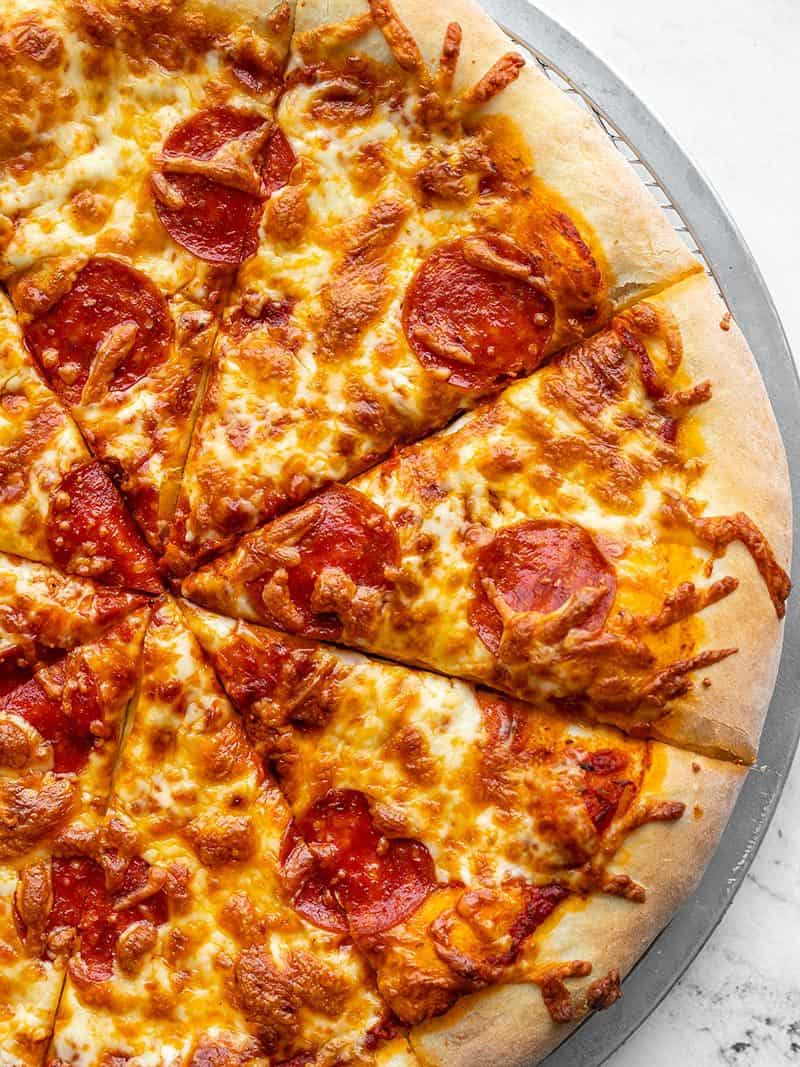 Homemade pizza dough is easy and costs pennies on the dollar compared to store bought. Make a batch now and freeze it for later! Budgetbytes.com Close up of a homemade pepperoni pizza