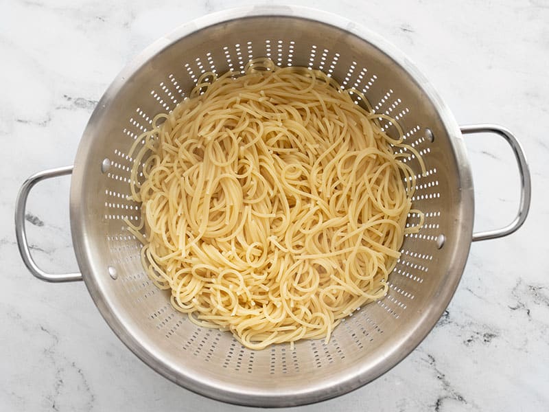 Cooked spaghetti in a colander.