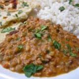 Close-up of dal served with basmati rice and naan bread.