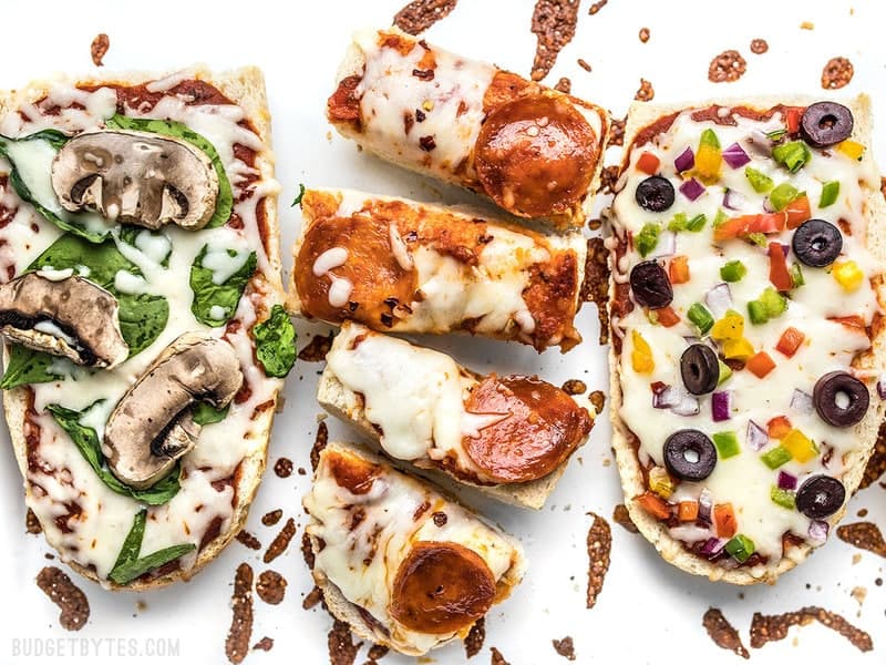 French Bread Pizza is the perfect budget-friendly fast and easy weeknight dinner. Customize the toppings to fit your taste buds or what you have on hand! Budgetbytes.com Close up of baked French Bread Pizza with one sliced into pieces