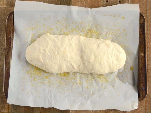 Risen Ciabatta Dough on baking sheet lined with parchment paper