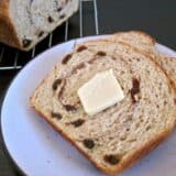 Slice of cinnamon raisin bread spread with butter.
