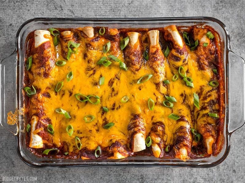 These award winning Chorizo and Sweet Potato enchiladas have a perfectly balanced sweet and spicy flavor that will leave you wanting more. BudgetBytes.com Baked Chorizo and Sweet Potato enchiladas in the casserole dish, garnished with green onion