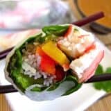 Open spring rolls served with chopsticks.