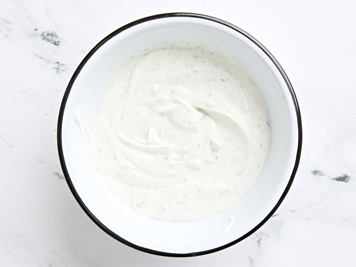 A homemade yogurt sauce for chicken shawarma wraps in a mixing bowl.