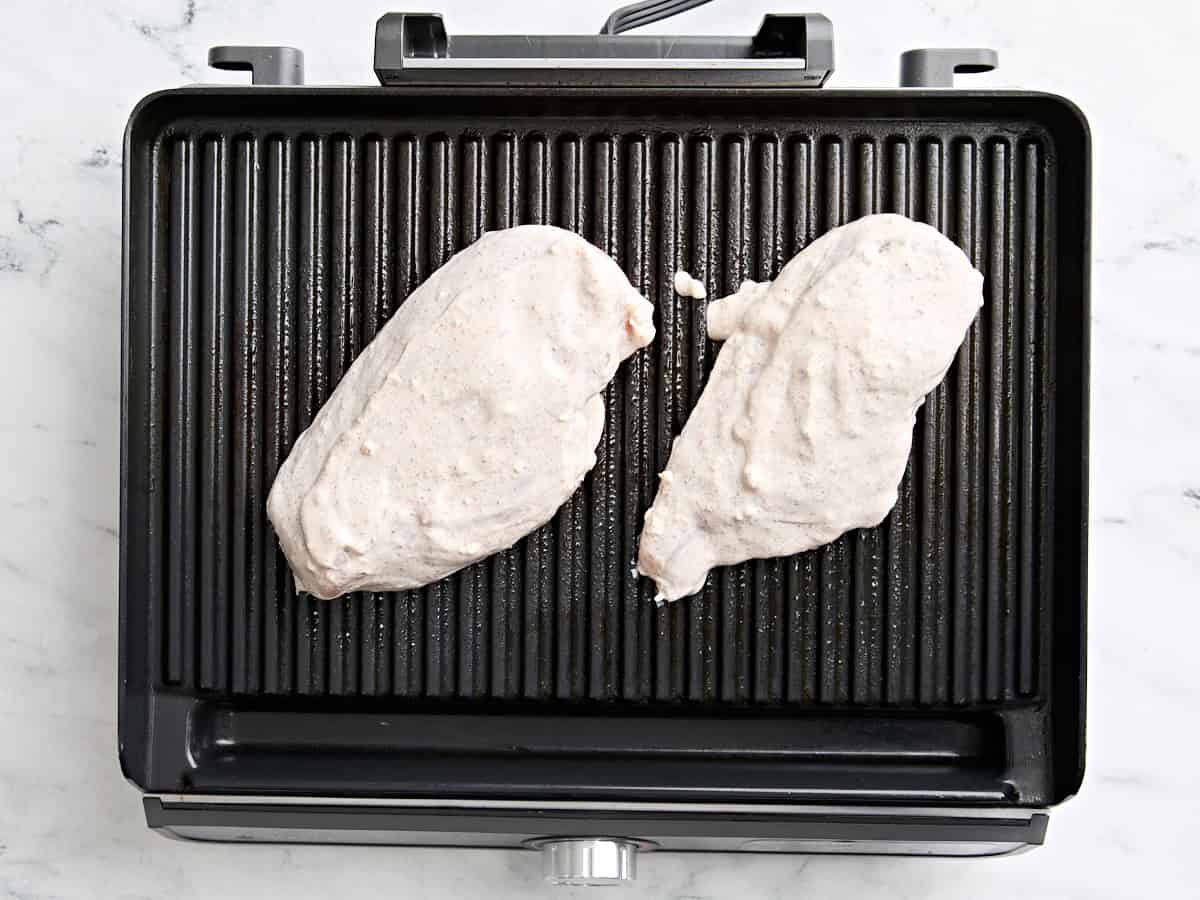 Marinaded chicken breasts on a grill.