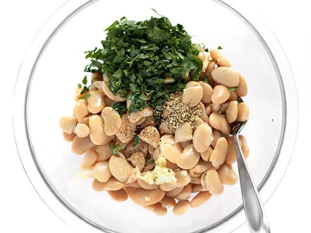 Marinated White Bean Salad Ingredients in mixing bowl with spoon
