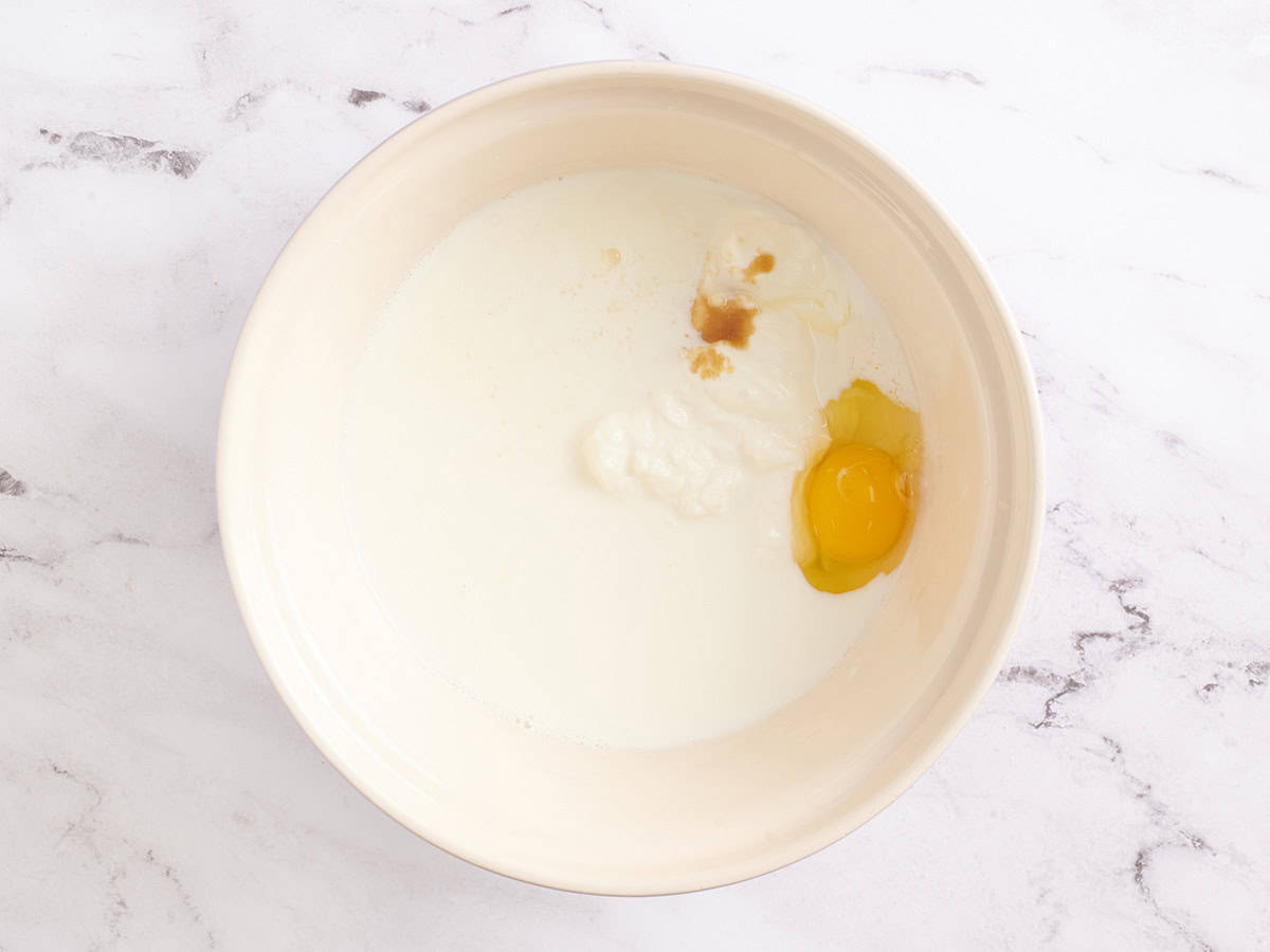 Milk, yogurt, and egg in a mixing bowl.