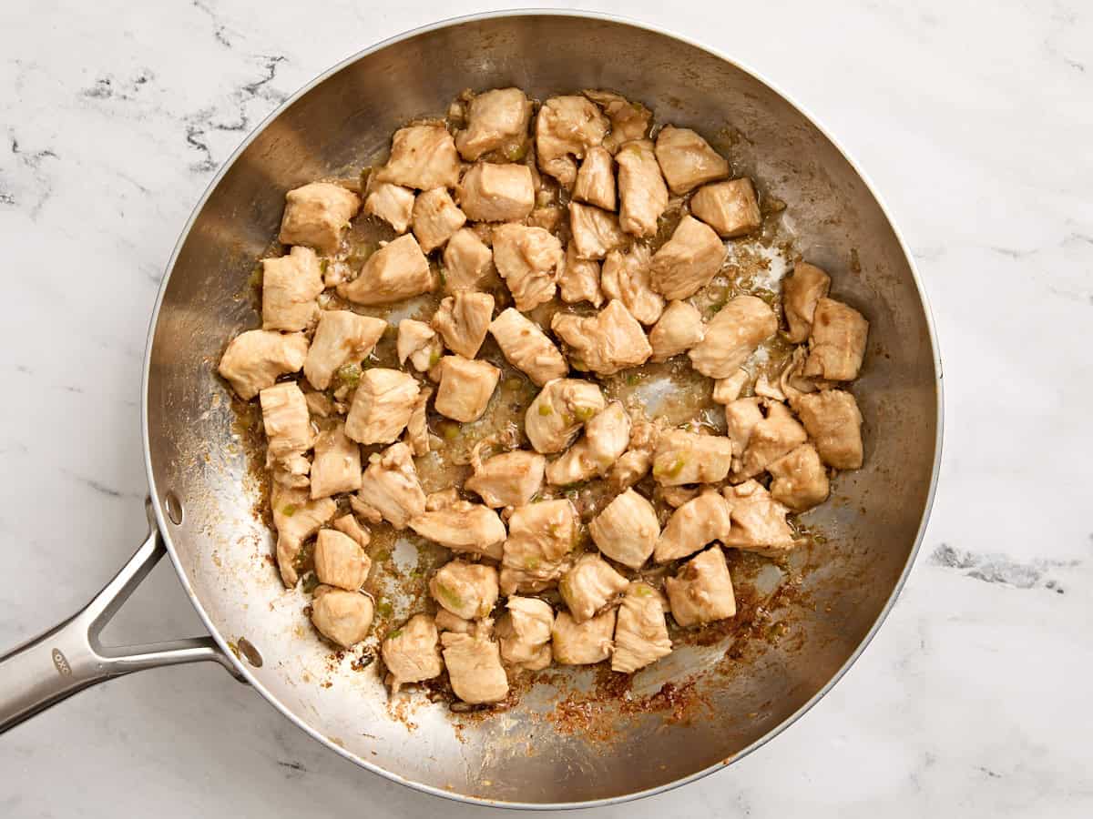 Cooked diced chicken breast in a skillet.