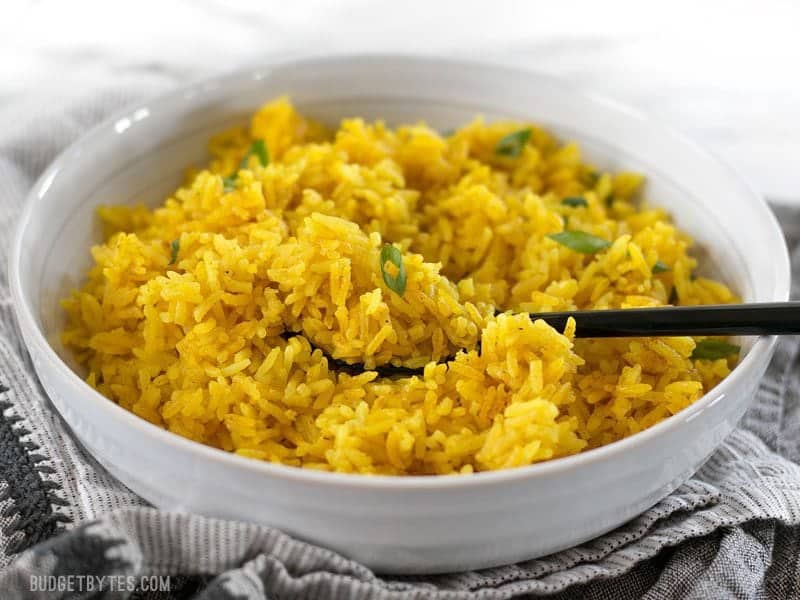 This savory Yellow Jasmine Rice combines warm and fragrant Indian spices and chicken broth to make the most flavorful rice you've ever tasted! BudgetBytes.com
