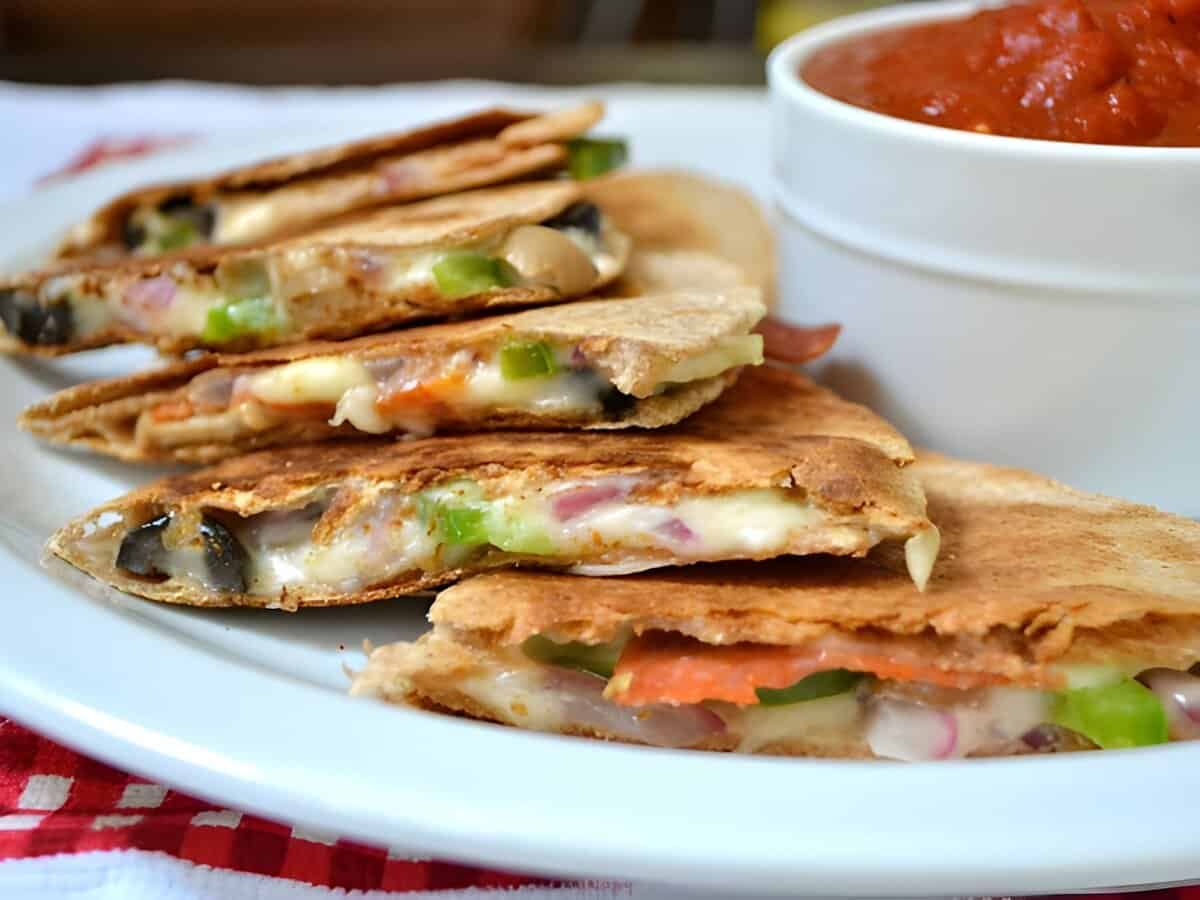 pizzadillas served on a plate next to marinara sauce