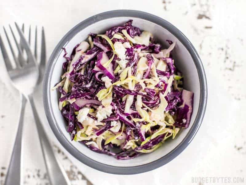 Top view of small bowl of slaw with forks on the side