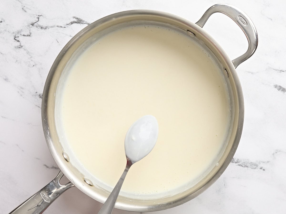 A spoon checking the thickness of cream sauce.
