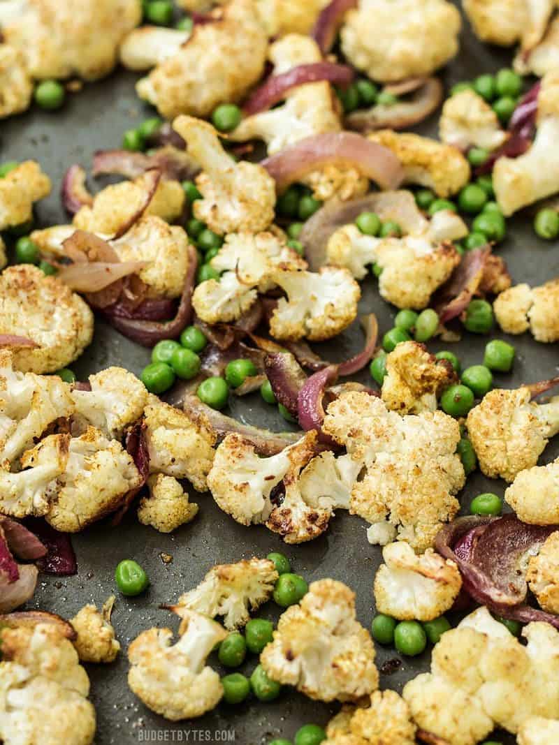 Curry Roasted Cauliflower is an easy way to turn boring cauliflower into a vibrantly spiced side dish with just a few ingredients. Budgetbytes.com Close view of Curry Roasted Cauliflower on a sheet pan
