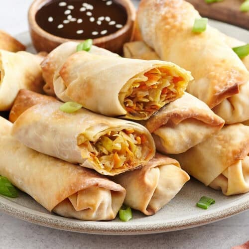 Side view of homemade vegetable egg rolls on a plate.