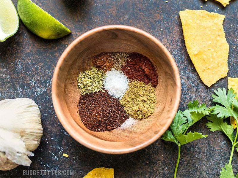 This homemade taco seasoning is quick, easy, inexpensive, full of flavor, and can be made with just a few basic spice cabinet staples. Budgetbytes.com Individual spices used for homemade taco seasoning in a small wooden bowl.