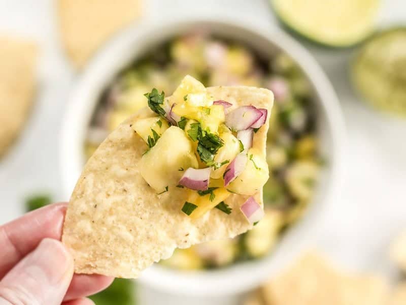 This easy pineapple salsa is fresh, vibrant, and perfect for chips, piling onto grilled meats, topping salads, or adding to any summer meal. BudgetBytes.com Close up of easy pineapple salsa on a tortilla chip