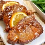 Orange molasses pork chops on a serving plate.