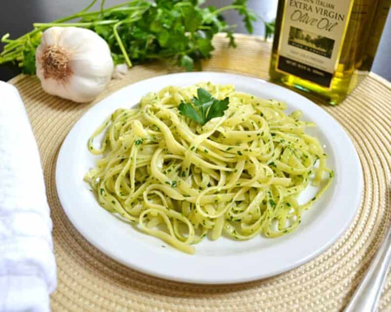Parsley pesto pasta on a white plate.