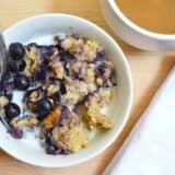 Blueberry banana oatmeal topped with fresh blueberries.