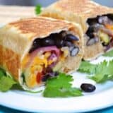 Roasted black bean vegetable burritos on a plate.