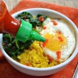 Yellow rice bowl drizzled with sriracha sauce.