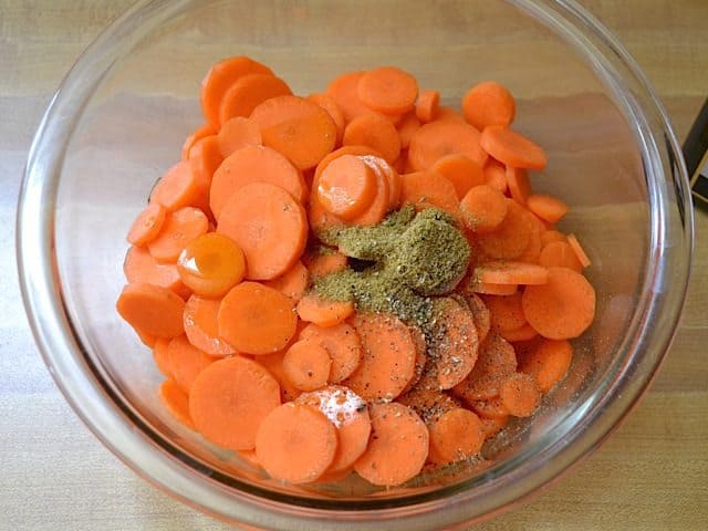 sliced carrots and seasoning in mixing bowl