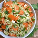 Carrot and orzo salad garnished with herbs.