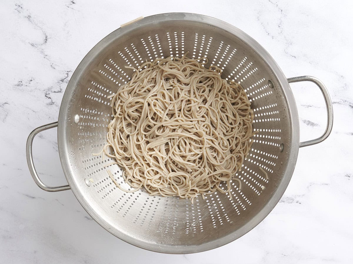 Cooked noodles in a colander.