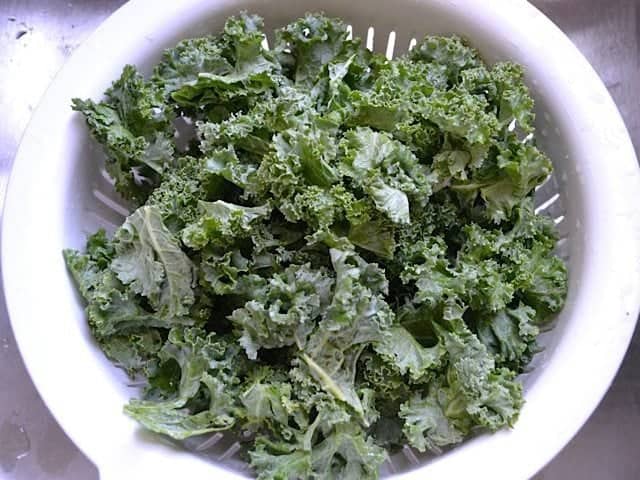 rinsing kale in colander