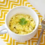 Hummus breakfast mug with fresh herbs.