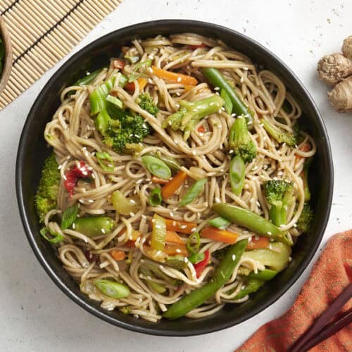 Overhead view of a bowl of teriyaki noodles and vegetables.