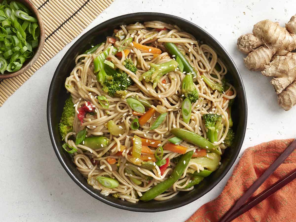 Overhead view of a bowl of teriyaki noodles and vegetables.