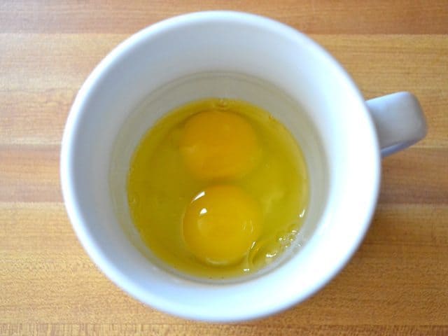Two raw eggs in a mug