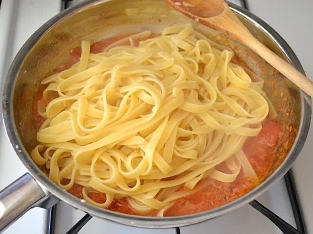 Cooked pasta added to skillet with sauce