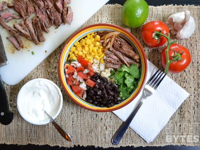 Top view of building a Southwest Steak Bowl with ingredients