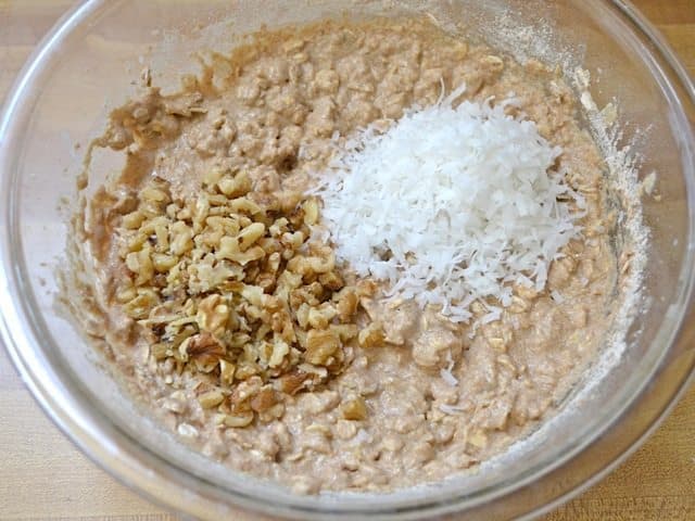 Chopped walnuts and shredded coconut added to mixing bowl