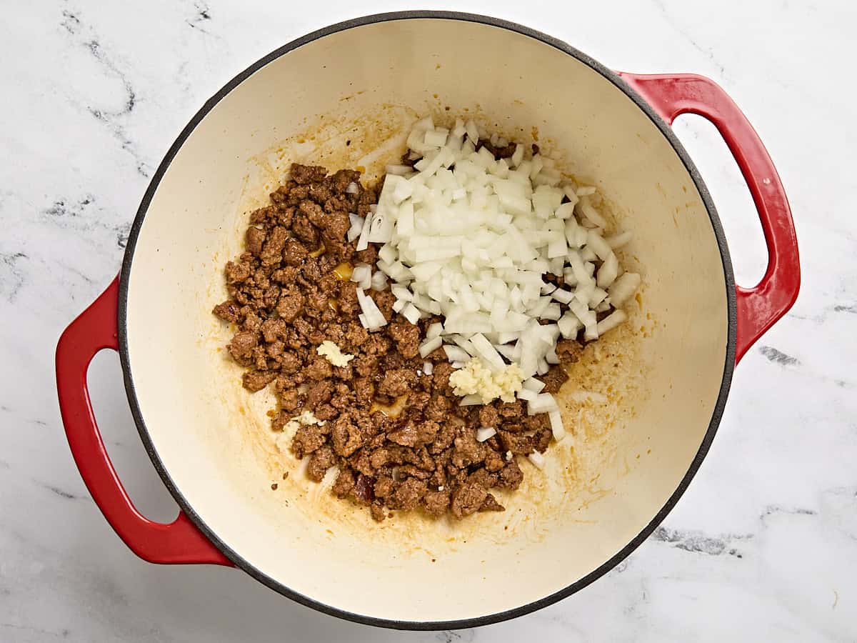 Minced garlic and diced onion added to the pot of cooked chorizo.