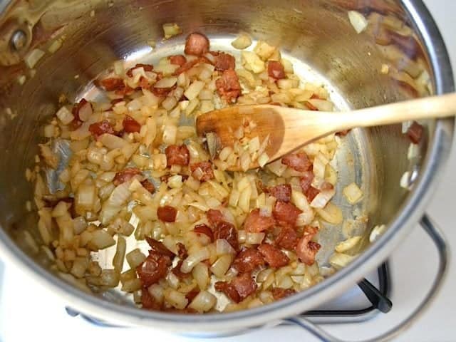 Onion and garlic added to bacon in pot