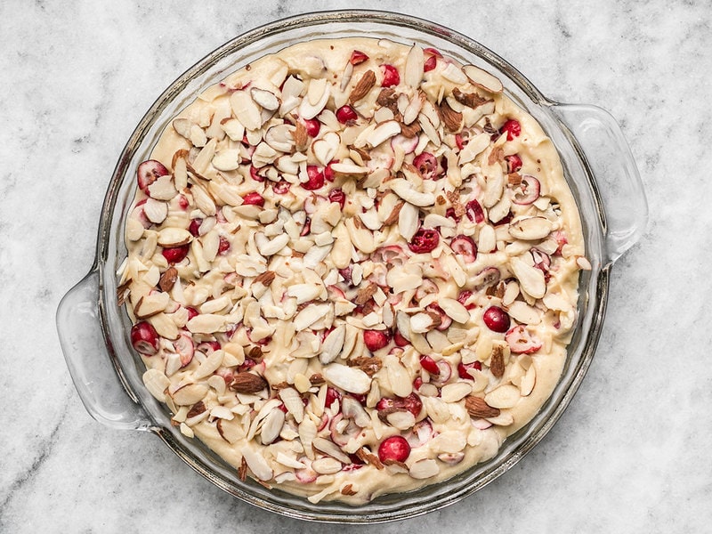 Cranberry Almond Cake batter in pie pan topped with sliced almonds
