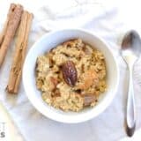Bowl of cinnamon date oatmeal topped with nuts.