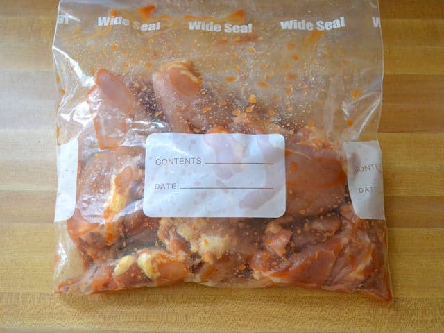 Marinade and chicken thighs put in zip lock bag to mix