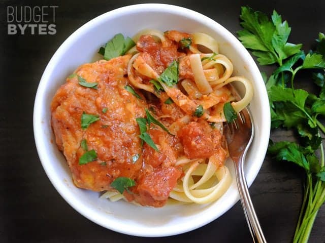 Chicken Arrabbiata over a bowl of noodles with a fork