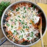 A skillet of kale and sausage dish served hot.