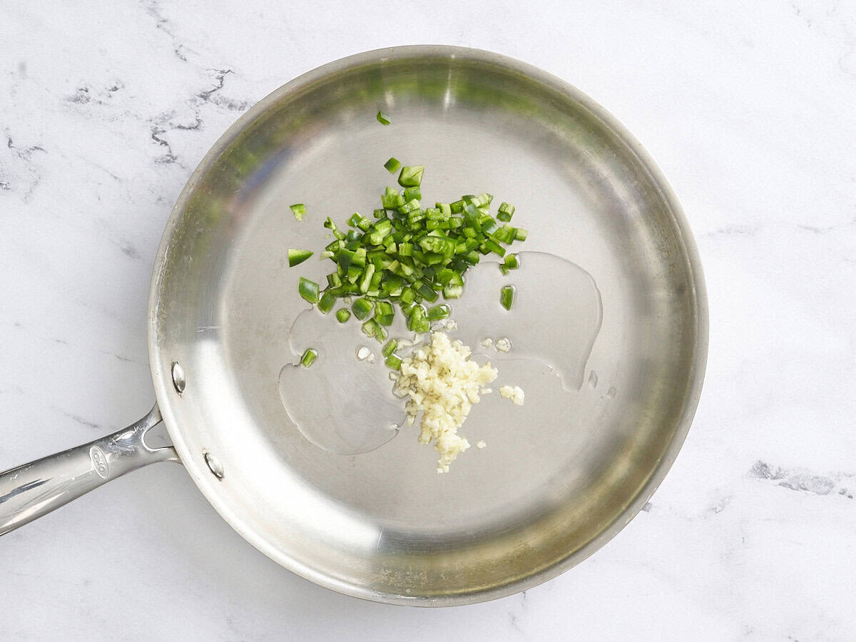 Diced jalapeno and garlic in a skillet.